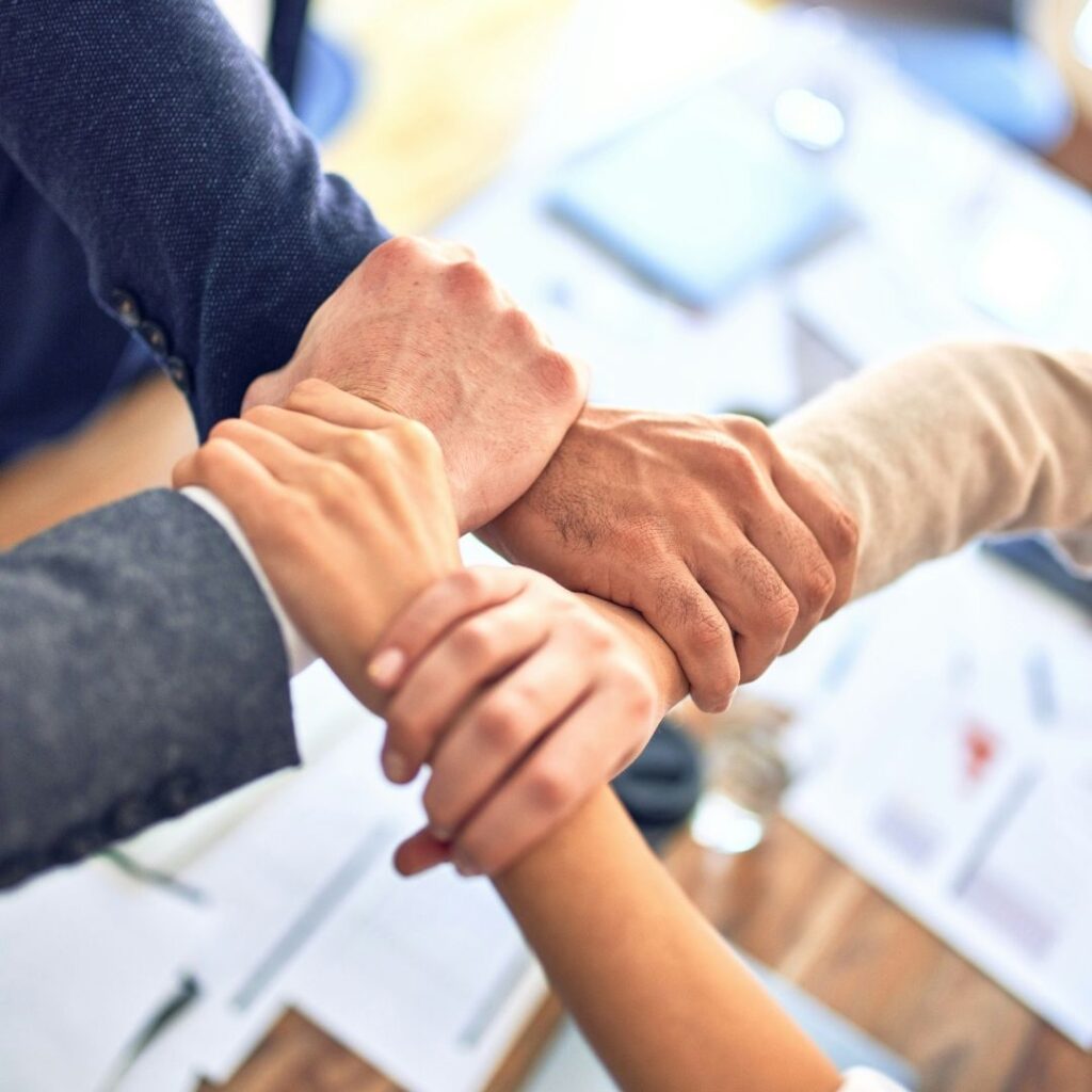 immagine di quattro persone che si tengono i polsi